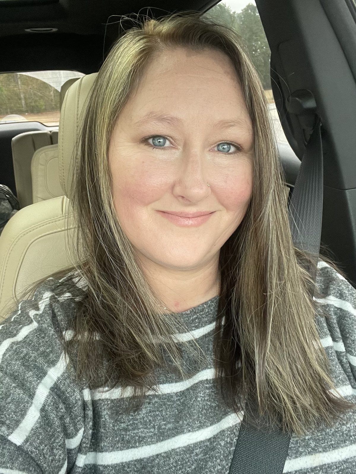 Kristie Horton smiling, in a gray striped sweater