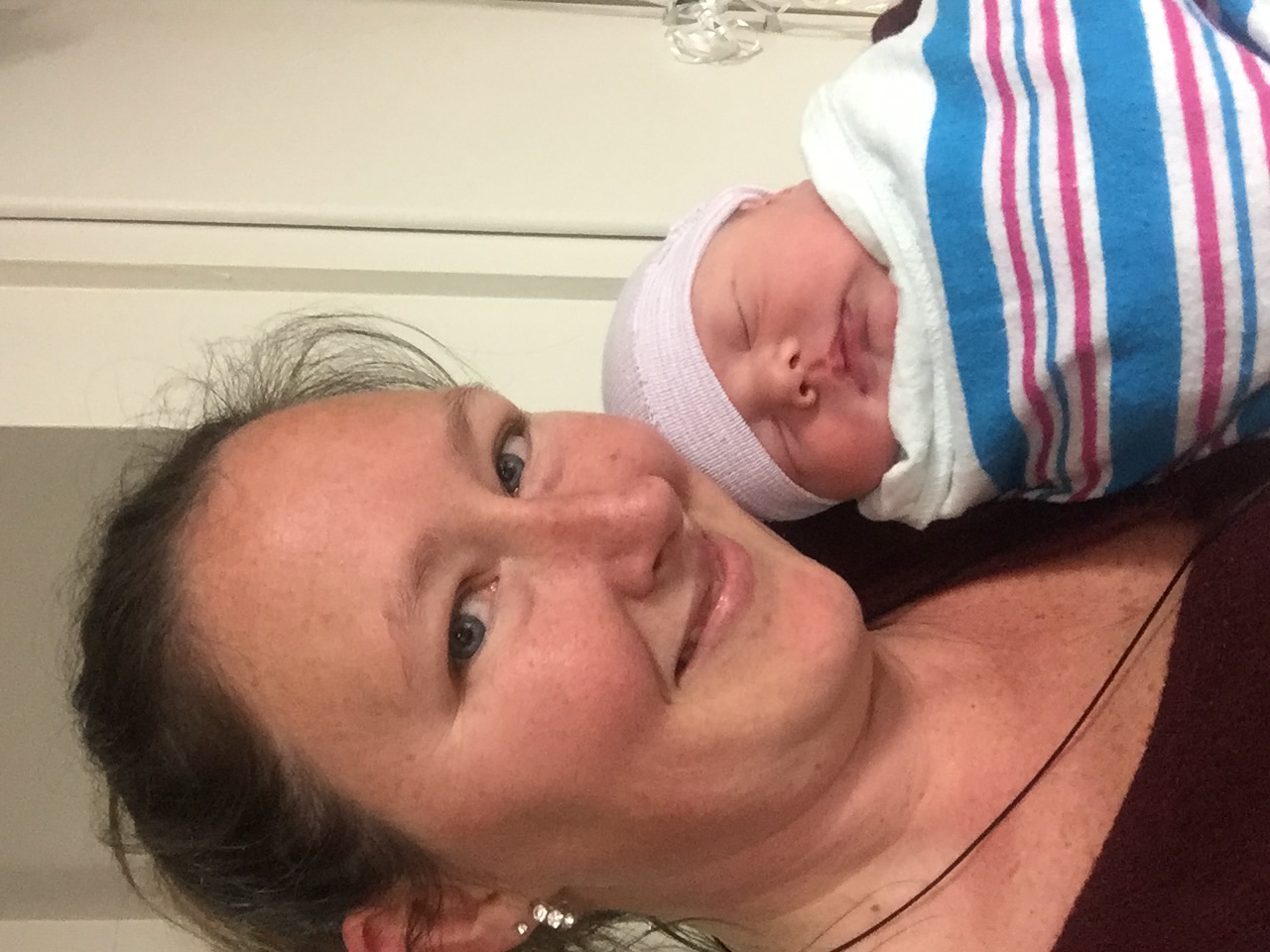 Kristie smiling with baby Eli Lee, just born